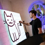 man drawing cat in a graffitty wall